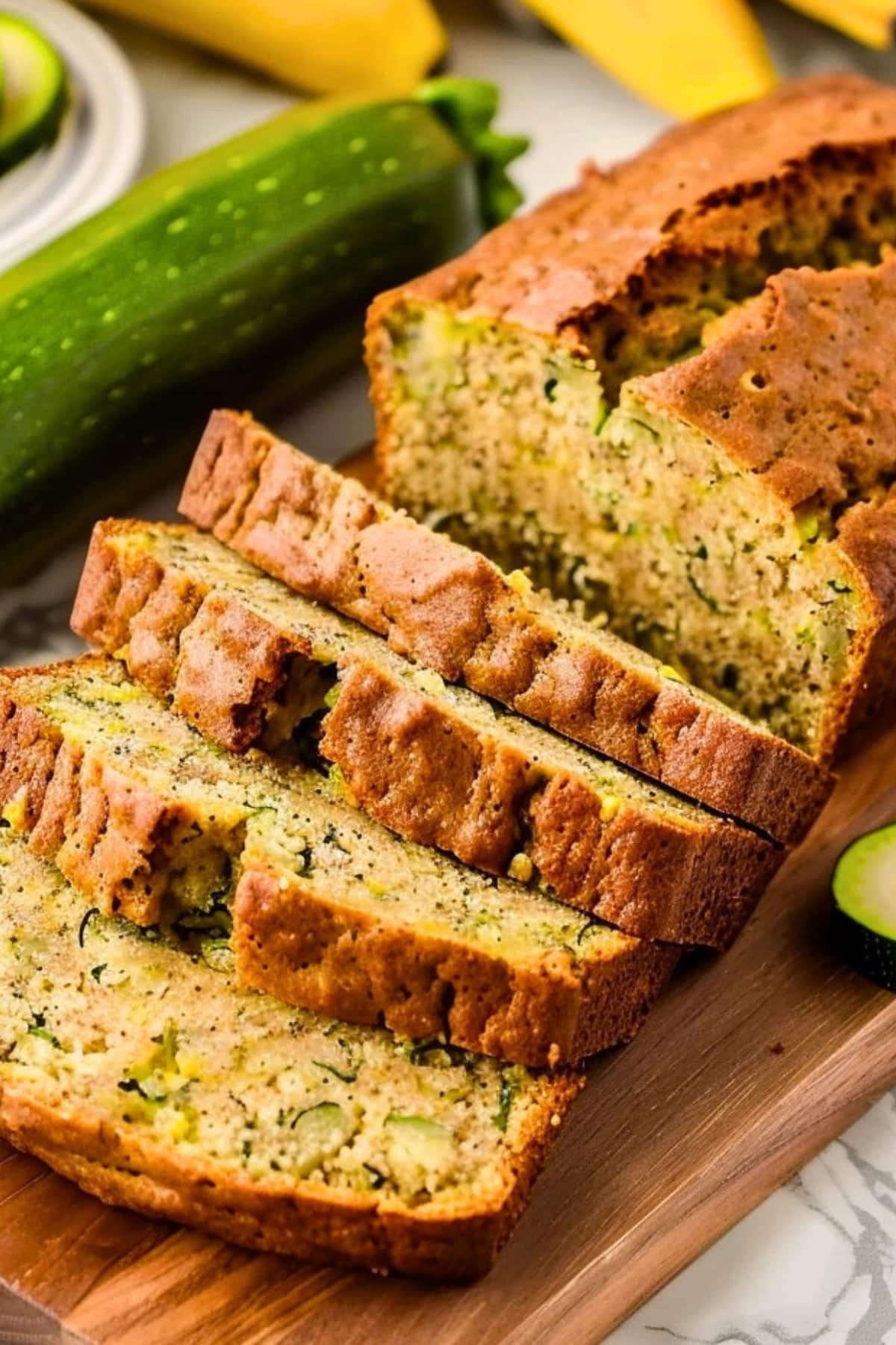 Banana zucchini bread sliced served on top of a wooden board.