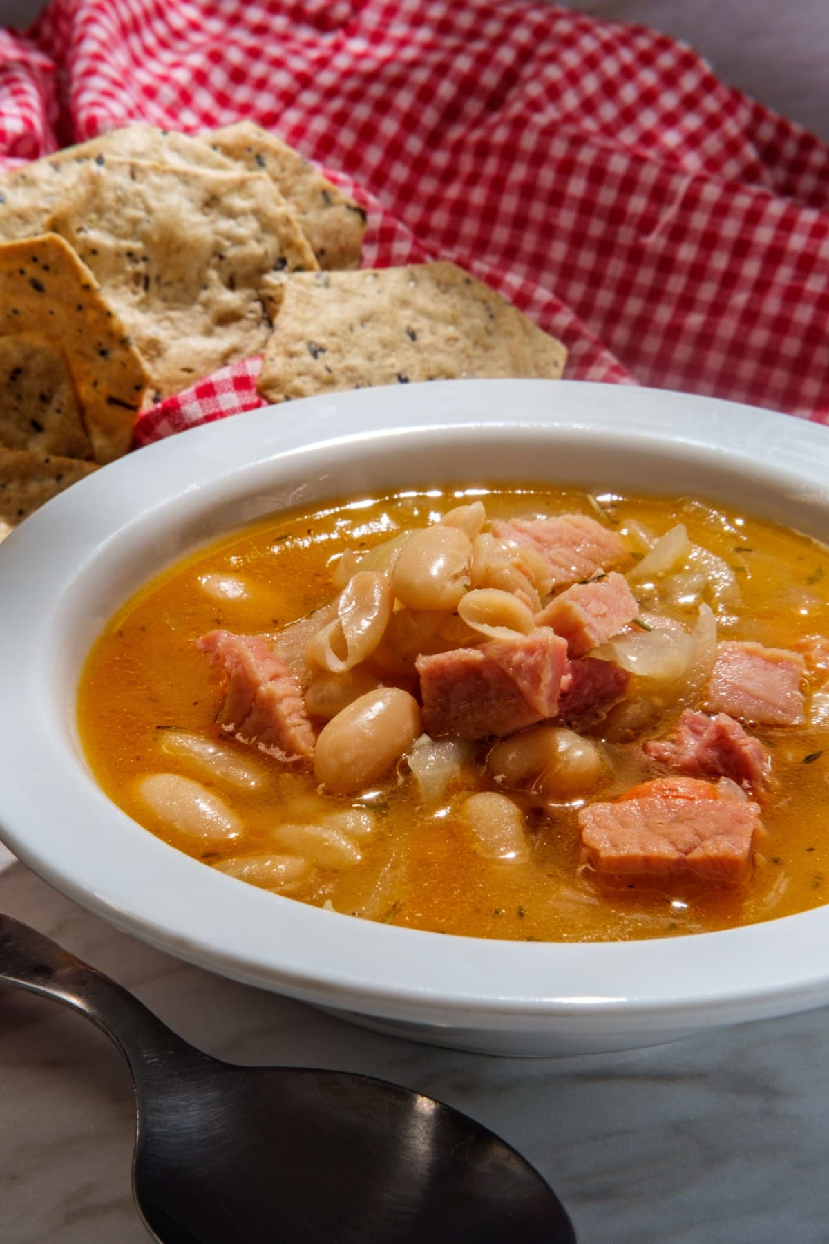 Senate bean soup in a bowl topped with chunks of ham.