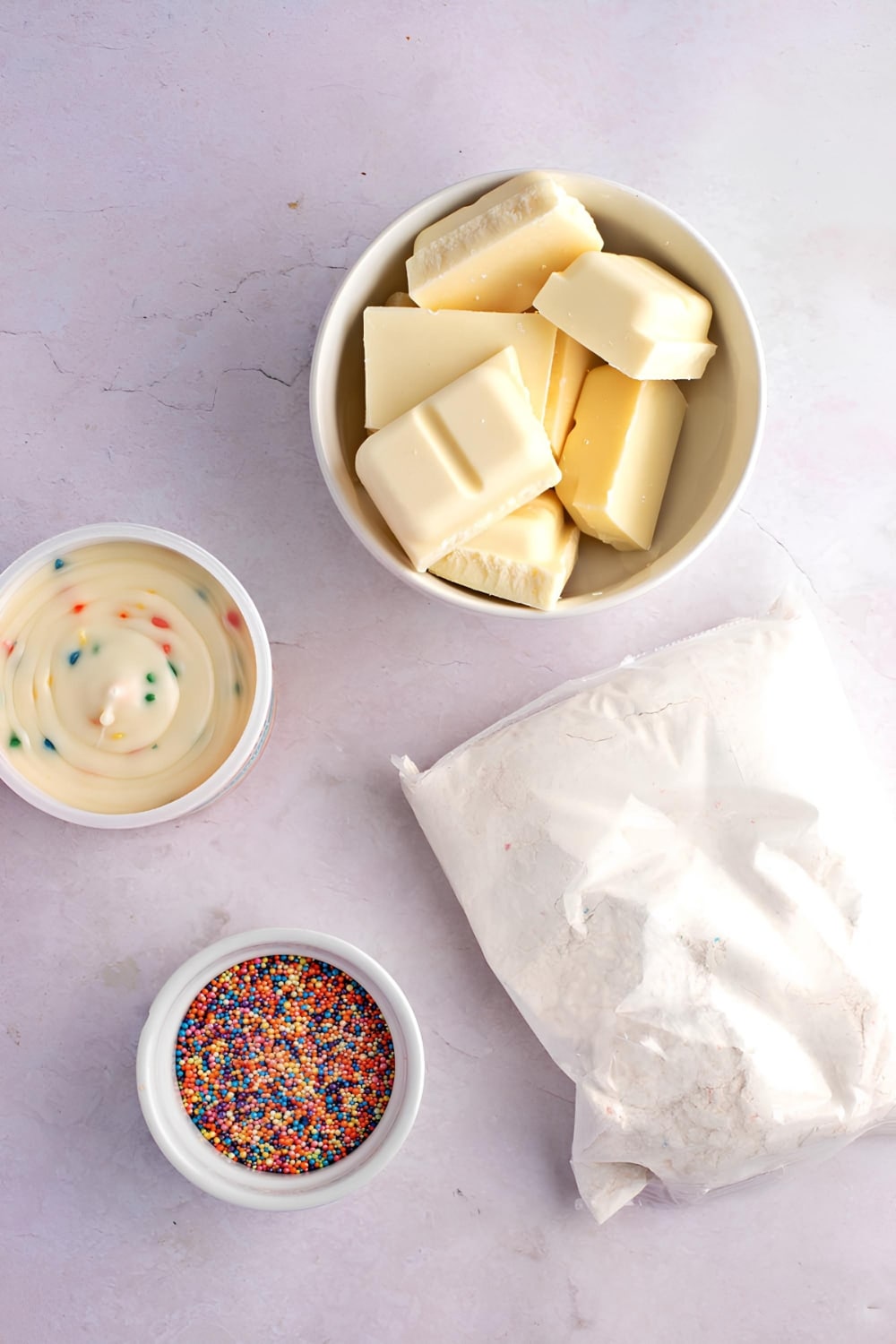 Cake Balls Ingredients in Bowls on White Marble Surface