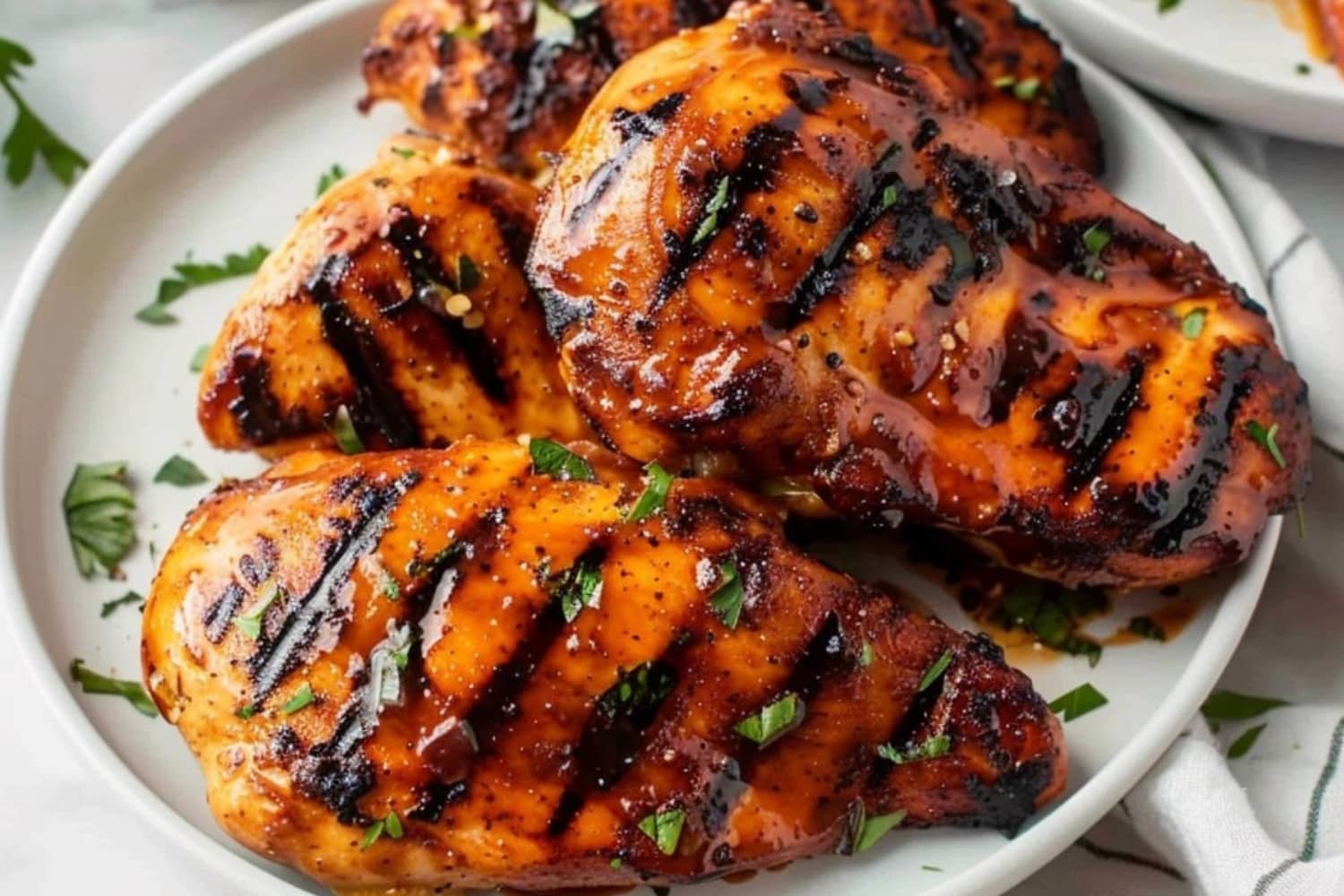 Gilled chicken breast served in a white plate.