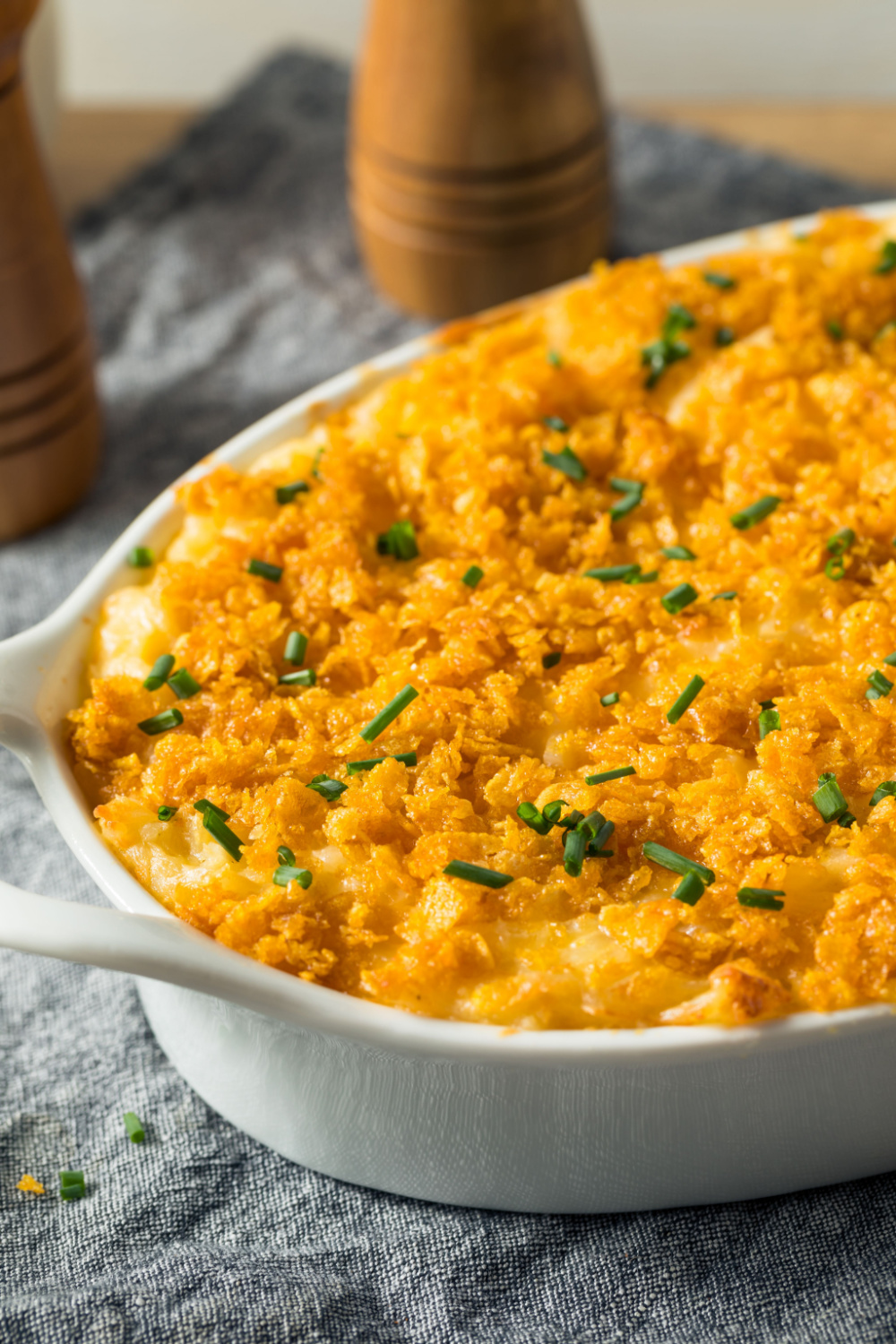 Cheesy Potato Casserole With Melted Cheese on Top, Garnished With Chopped Onion Leaves on Top