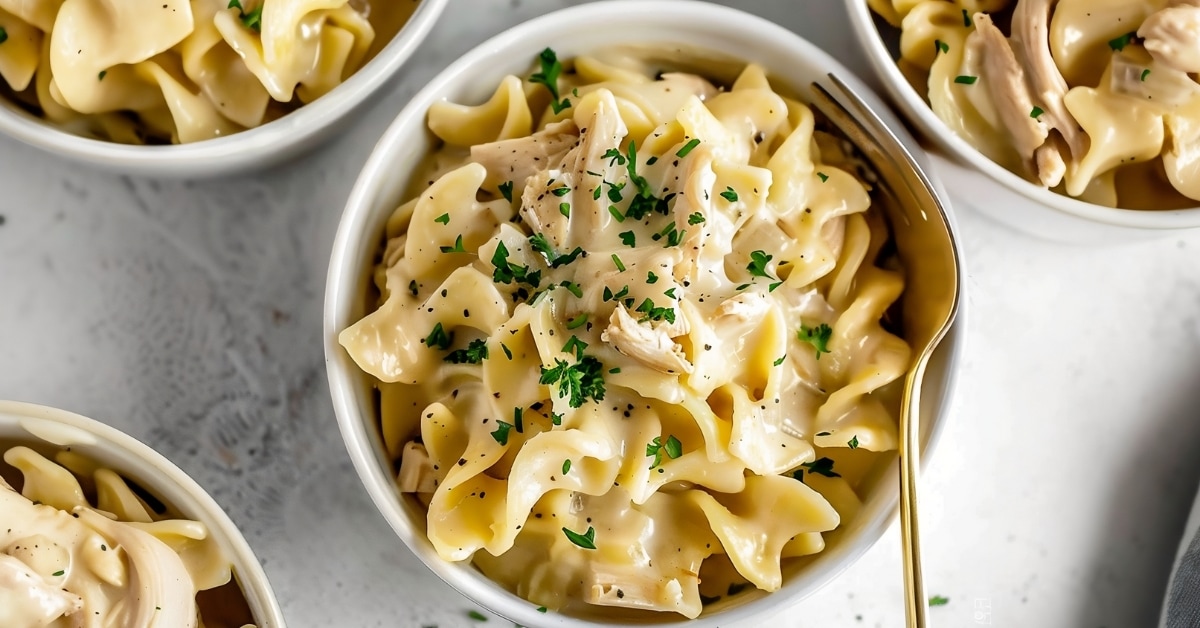 Shredded chicken and egg noodles in a bowl with cream of mushroom soup