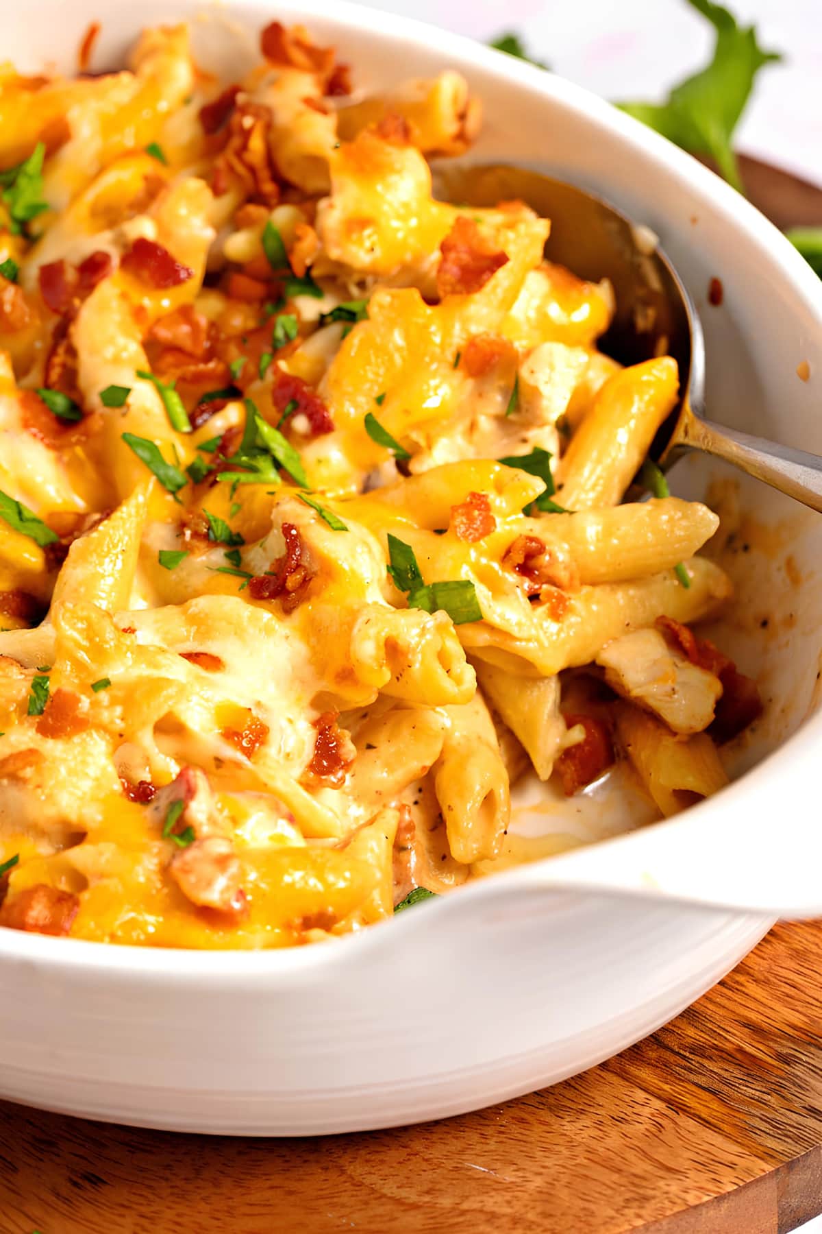close up of Chicken Bacon Ranch Casserole with bacon bits in a white dish. 