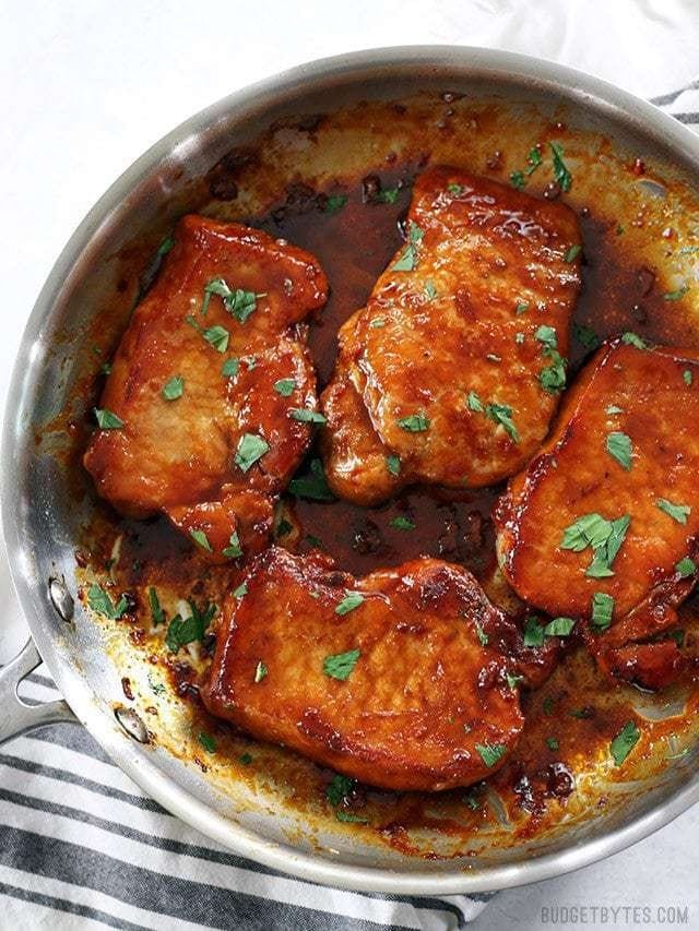 Glazed pork chop cooked in a stainless pan. 