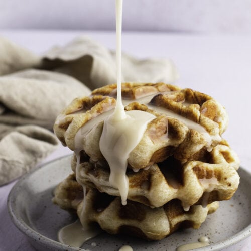 Pouring Syrup Over a Cinnamon Roll Waffles on a Plate