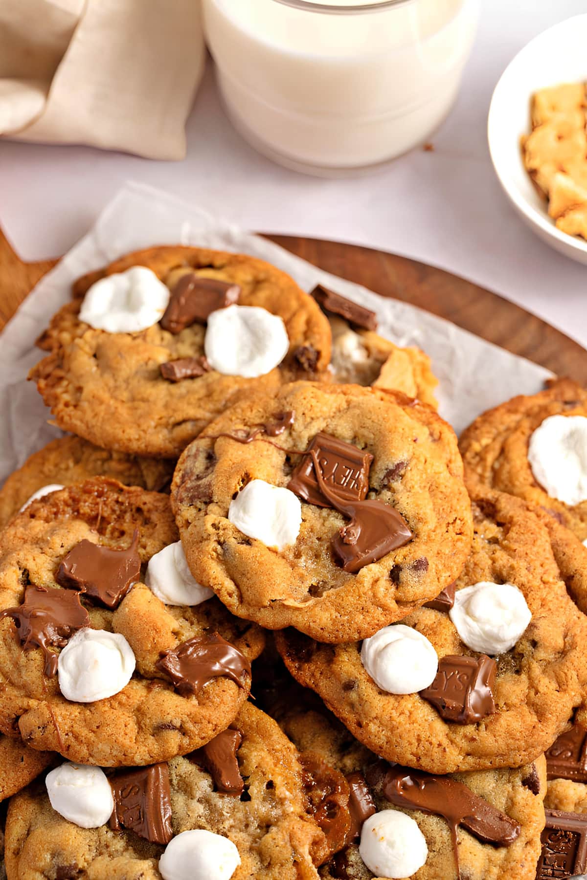 S’mores Cookies with chocolate and marshmallow on a wooden board with parchment paper lining. 