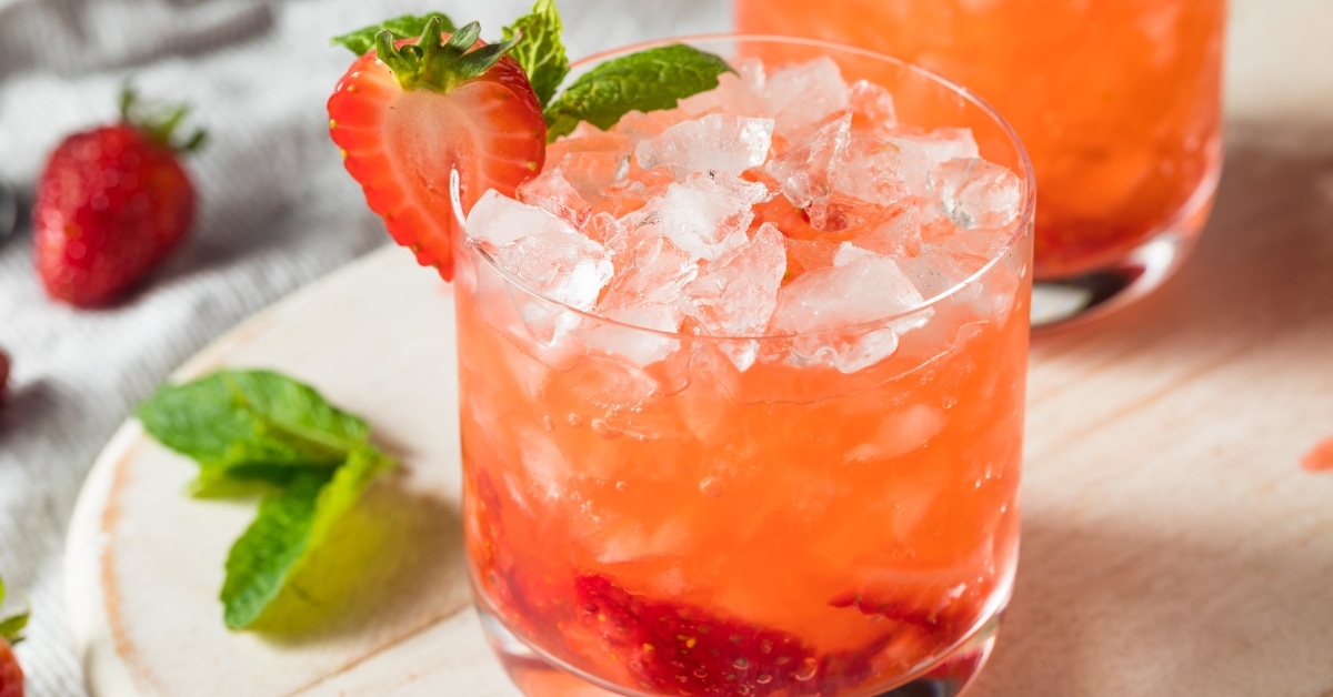 Strawberry gin cocktail with basil and sliced strawberries.