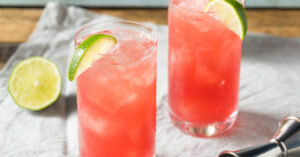 A pair of bay breeze cocktail with lime and jigger on a table