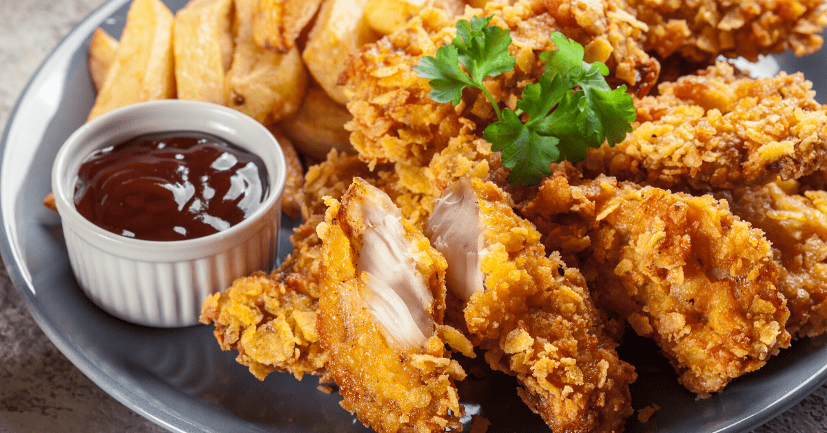 Crispy fried chicken served on a plate with fries and ketchup